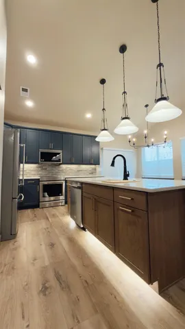 a kitchen with stainless steel appliances kitchen island granite countertop a sink counter space cabinets and stainless steel appliances