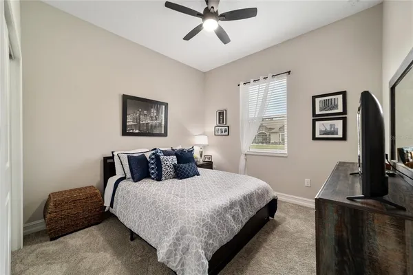 a bedroom with a bed a couch and a flat screen tv