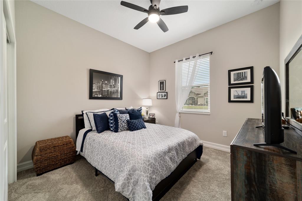 906 Southeast 41st Street Ocala, FL 34480 - Photo 25 of 37 a bedroom with a bed a couch and a flat screen tv