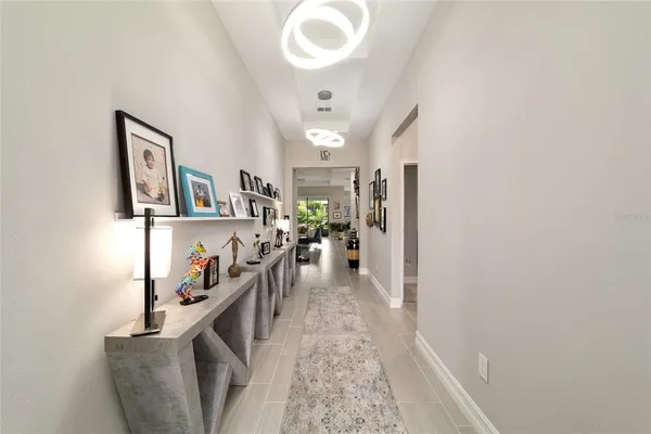 a view of a hallway with workspace and living room