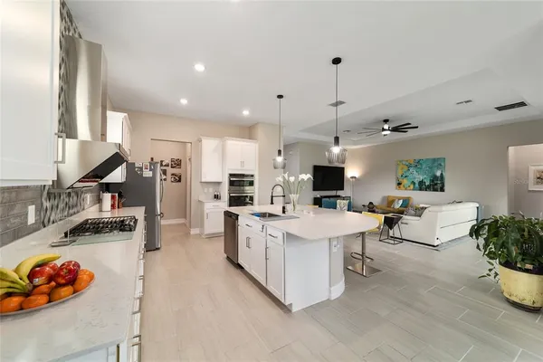 a open kitchen with stainless steel appliances kitchen island granite countertop a stove and a sink