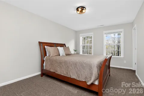 a bed sitting in a bedroom next to a window