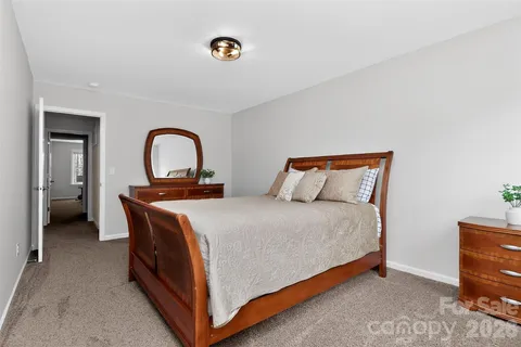 a bed sitting in a bedroom next to a cabinet and mirror