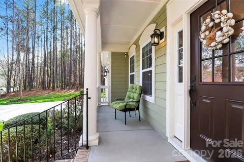 a front view of a house with a garden and trees
