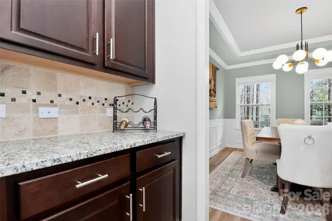 a kitchen with a sink dishwasher a dining table and chairs with wooden floor
