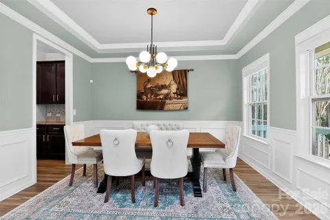 a view of a dining room with furniture wooden floor and chandelier