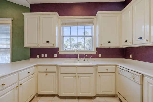 a kitchen with white cabinets and white appliances