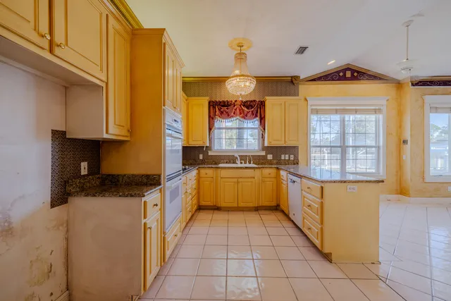 a large kitchen with stainless steel appliances granite countertop a sink and cabinets