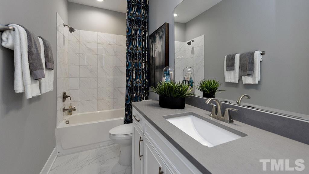 6948 Leesville Road, Unit 14 Raleigh, NC 27613 - Photo 12 of 19 a bathroom with a sink a toilet a tub and shower