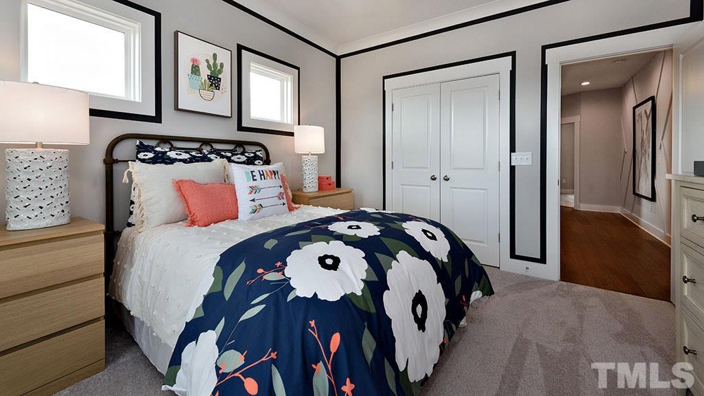 6948 Leesville Road, Unit 14 Raleigh, NC 27613 - Photo 18 of 19 a bedroom with a bed and a lamp on dresser with wooden floor