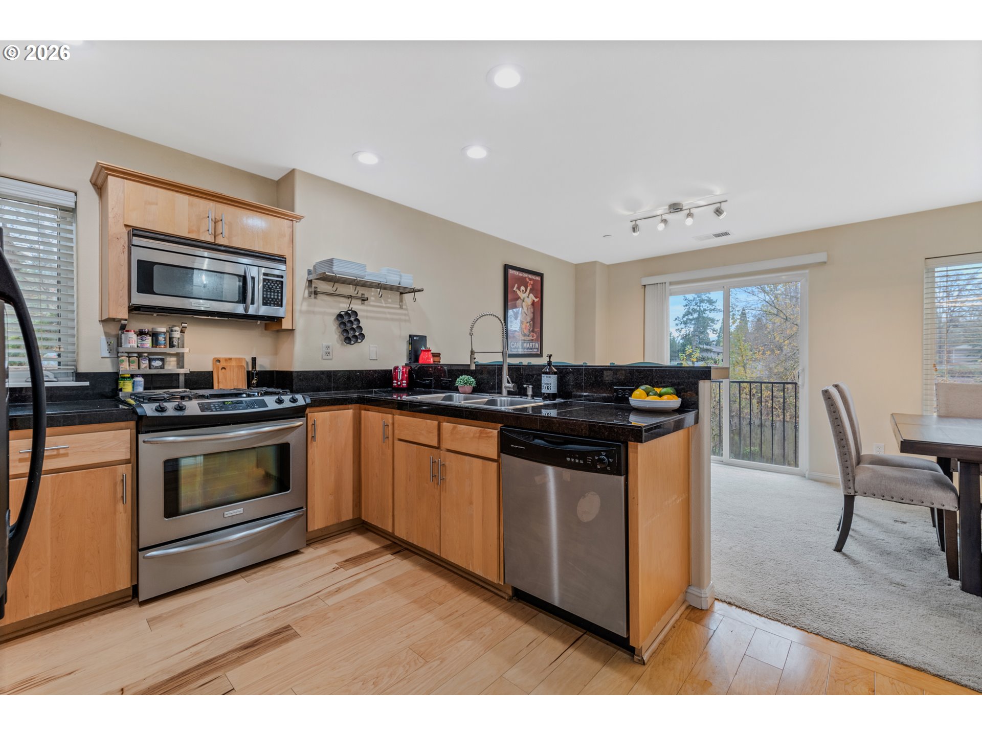 2924 Southwest Tranquility Terrace Beaverton, OR 97003 - Photo 14 of 39 a kitchen with stainless steel appliances kitchen island granite countertop a stove a sink and a microwave