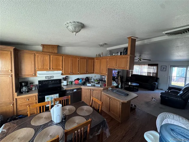 a living room with furniture kitchen view and a window