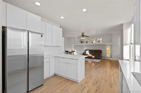 a kitchen with a refrigerator and a stove top oven