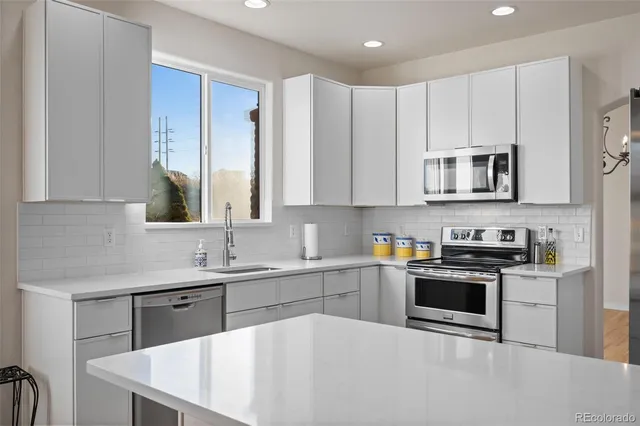 a kitchen with stainless steel appliances granite countertop a stove a sink a microwave and cabinets
