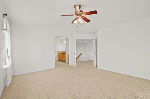 an empty room with ceiling fan and window
