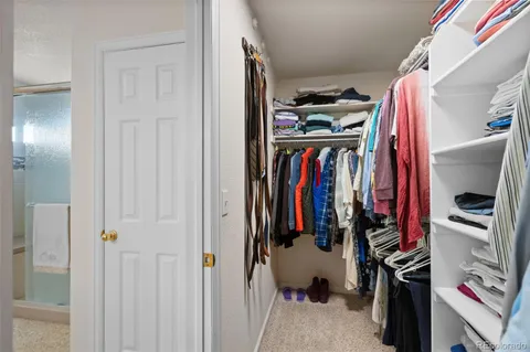 a view of walk in closet with clothes