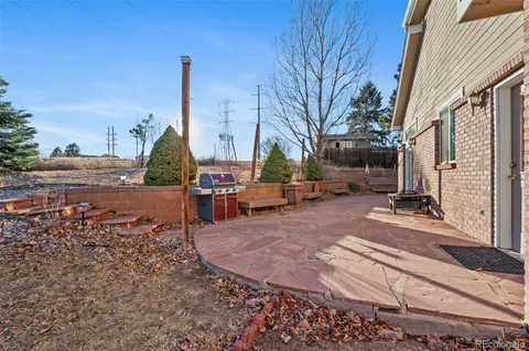 a view of a patio with a table chairs and a fire pit