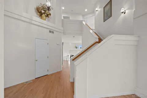a view of a hallway with wooden floor and staircase