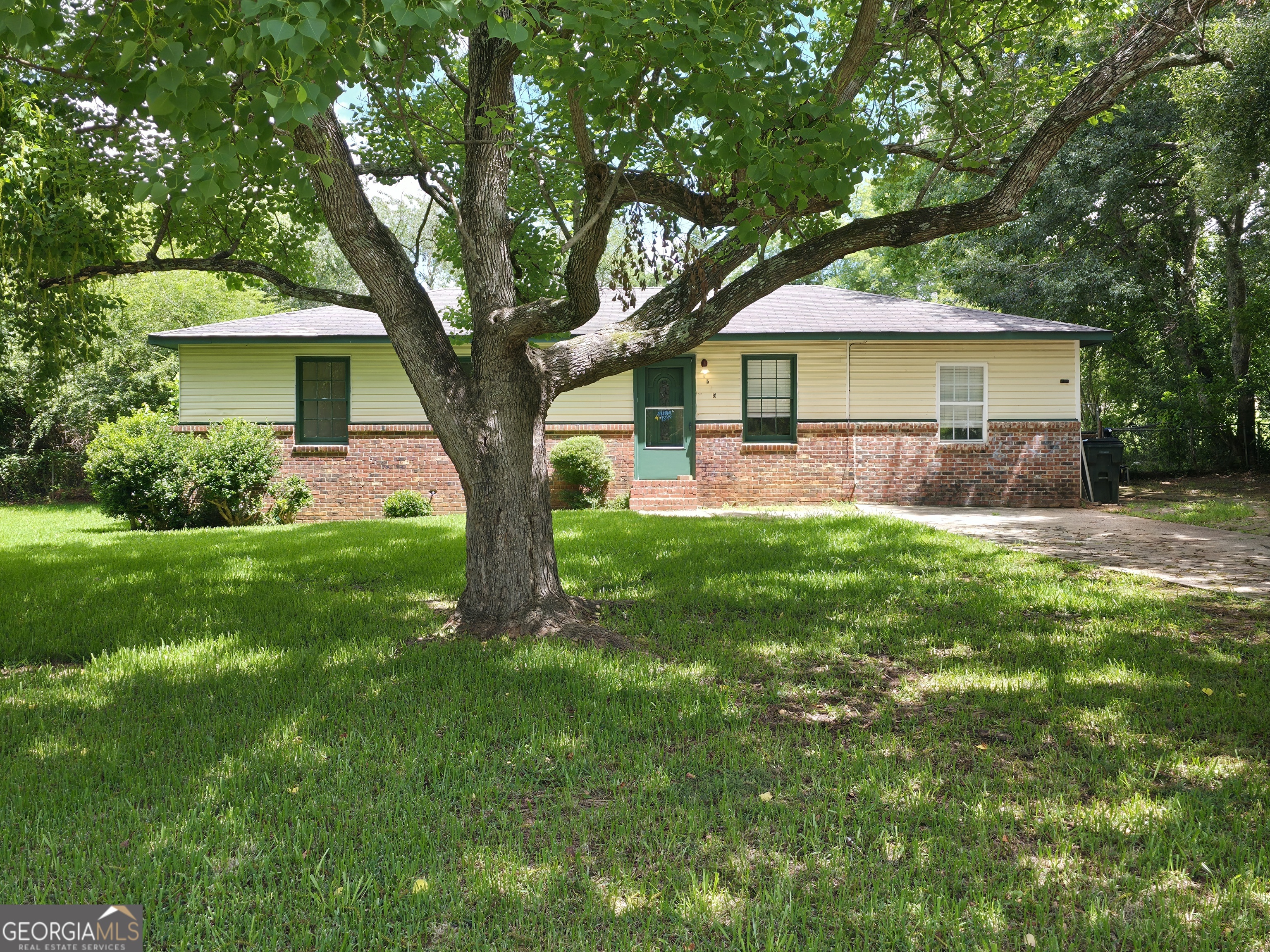a front view of a house with a yard and trees