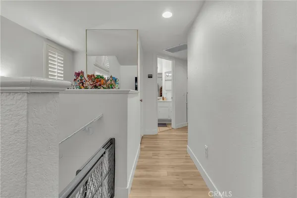 a view of a hallway with wooden floor and staircase