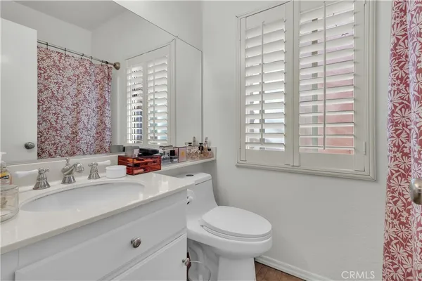 a bathroom with a sink a toilet and a window