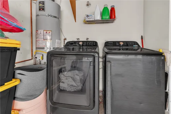 a utility room with dryer washer and a view of living room