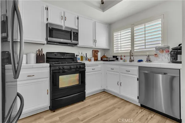 a kitchen with stainless steel appliances a stove microwave and sink