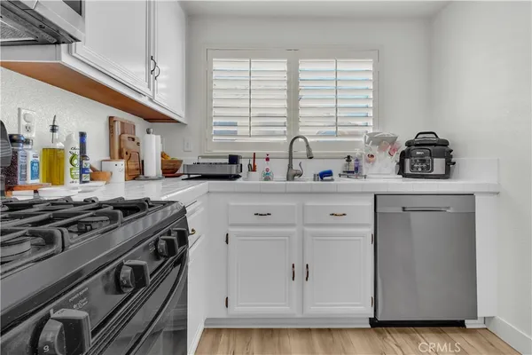 a kitchen with stainless steel appliances granite countertop a sink stove and cabinets
