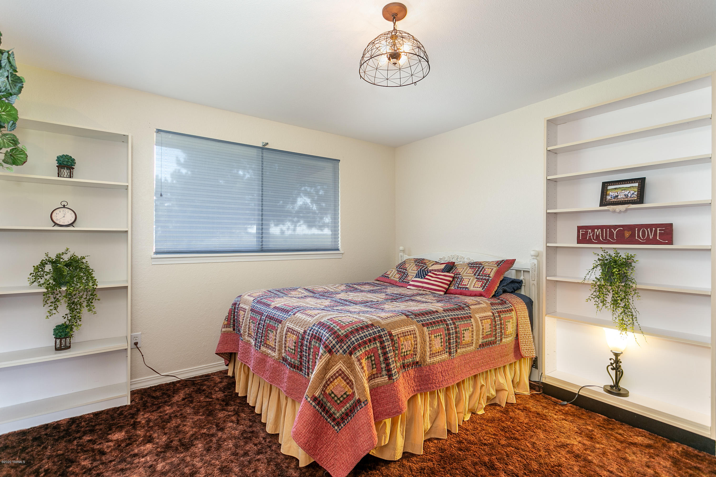 2770 South Satus Road Toppenish, WA 98948 - Photo 21 of 41 a bedroom with a bed and a chandelier