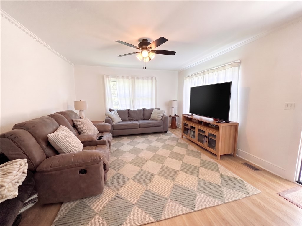 710 O Neal Street Belton, SC 29627 - Photo 6 of 18 A well-lit gathering space features light wood flooring, an eye-catching geometric rug, and ample natural light from large windows.