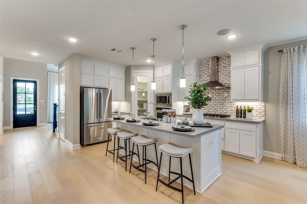 1116 Lakeview Lane Argyle, TX 76226 - Photo 9 of 40 a kitchen with stainless steel appliances kitchen island granite countertop a refrigerator a sink dishwasher and white cabinets with wooden floor