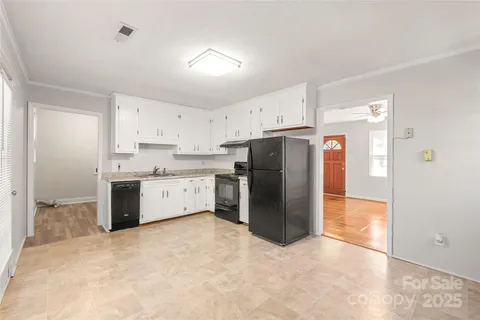 a kitchen with granite countertop white cabinets and refrigerator