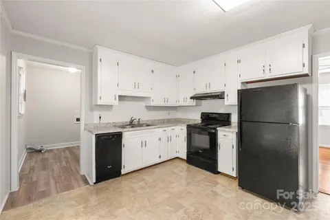 a kitchen with stainless steel appliances granite countertop a refrigerator stove and sink