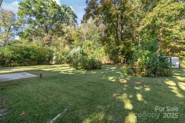 a view of a house with backyard and trees