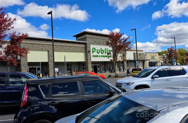 a front view of a building with retail shops and traffic signal