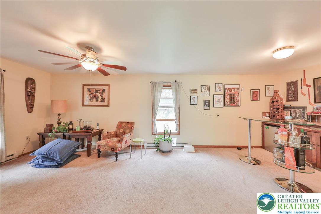 4608 Pine Ridge Drive West Bushkill, PA 18324 - Photo 16 of 62 A versatile living area with a ceiling fan, plush carpeting, and a sun-filled window.