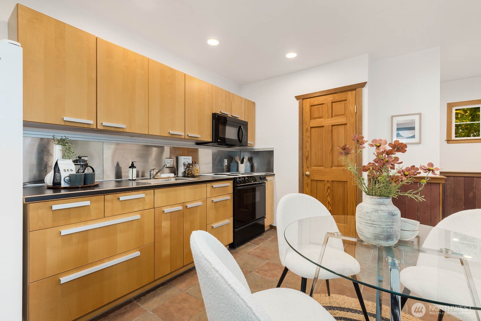 17110 66th Place West Edmonds, WA 98026 - Photo 31 of 38 a kitchen with stainless steel appliances granite countertop a table and chairs in it