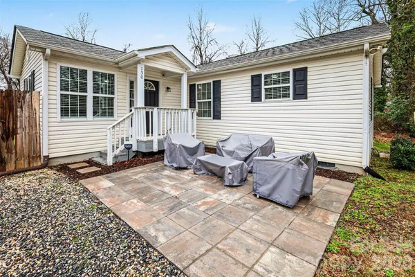a view of a patio with a table and chairs and wooden fence