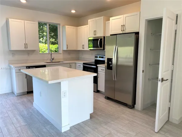 a kitchen with wooden cabinets a refrigerator and a sink