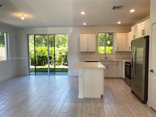 a kitchen with a sink a counter top space stainless steel appliances and a large window