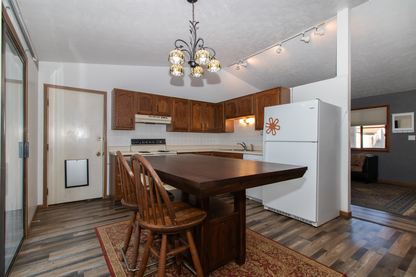 105 Churchill Road Normal, IL 61761 - Photo 6 of 24 a kitchen with stainless steel appliances granite countertop a refrigerator a sink dishwasher a stove and a dining table with wooden floor