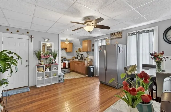 a view of a dining room and kitchen with furniture window and wooden floor