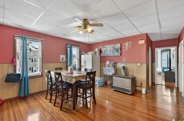 a view of a dining room with furniture a chandelier and wooden floor