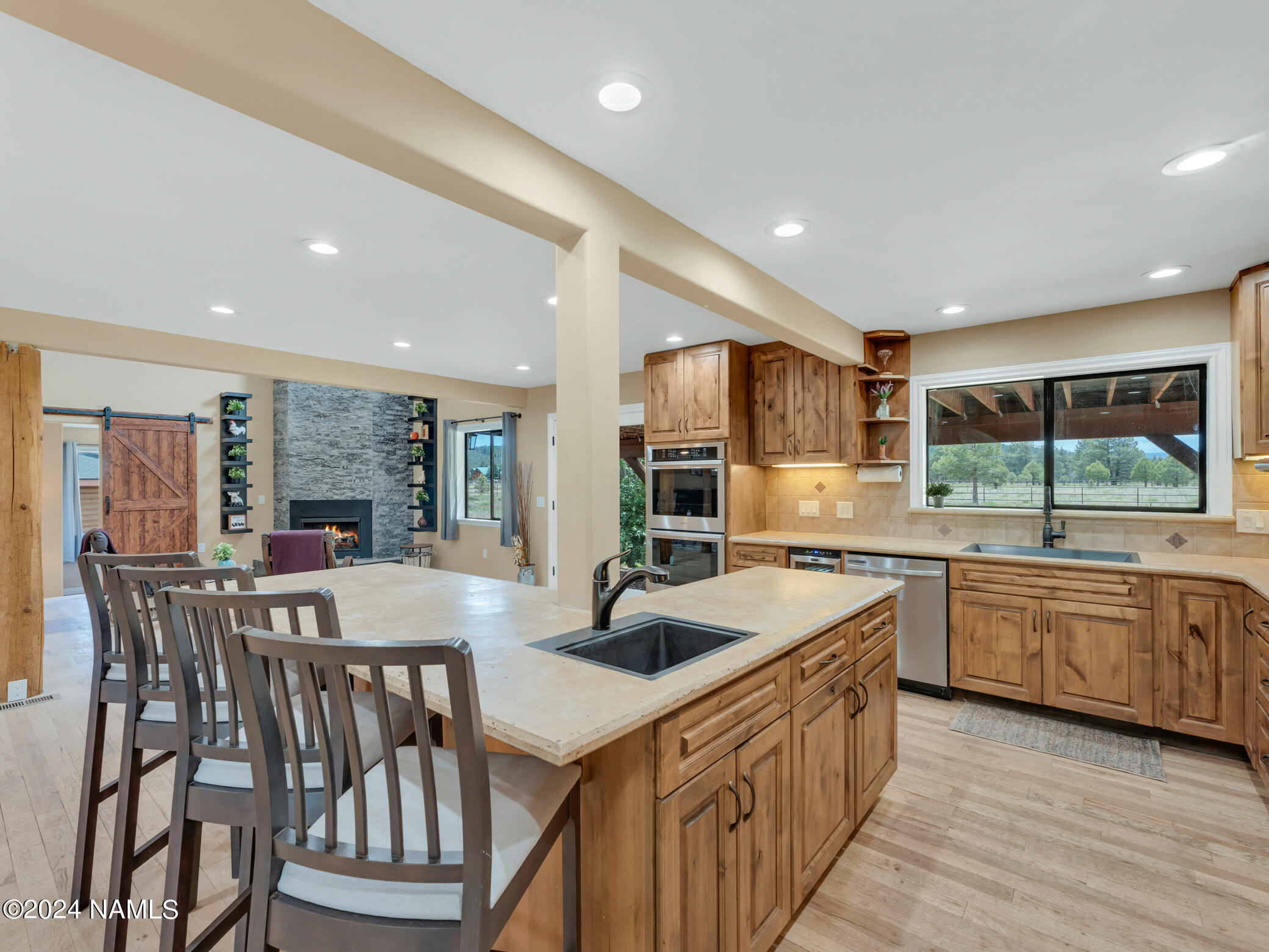15312 Rabbit Brush Road Parks, AZ 86018 - Photo 20 of 59 a kitchen with stainless steel appliances granite countertop a kitchen island a stove a sink a dining table and chairs