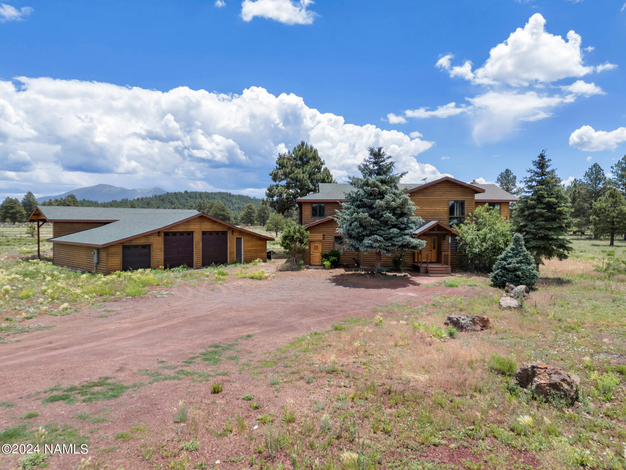 15312 Rabbit Brush Road Parks, AZ 86018 - Photo 3 of 59 a front view of a house with a yard and trees