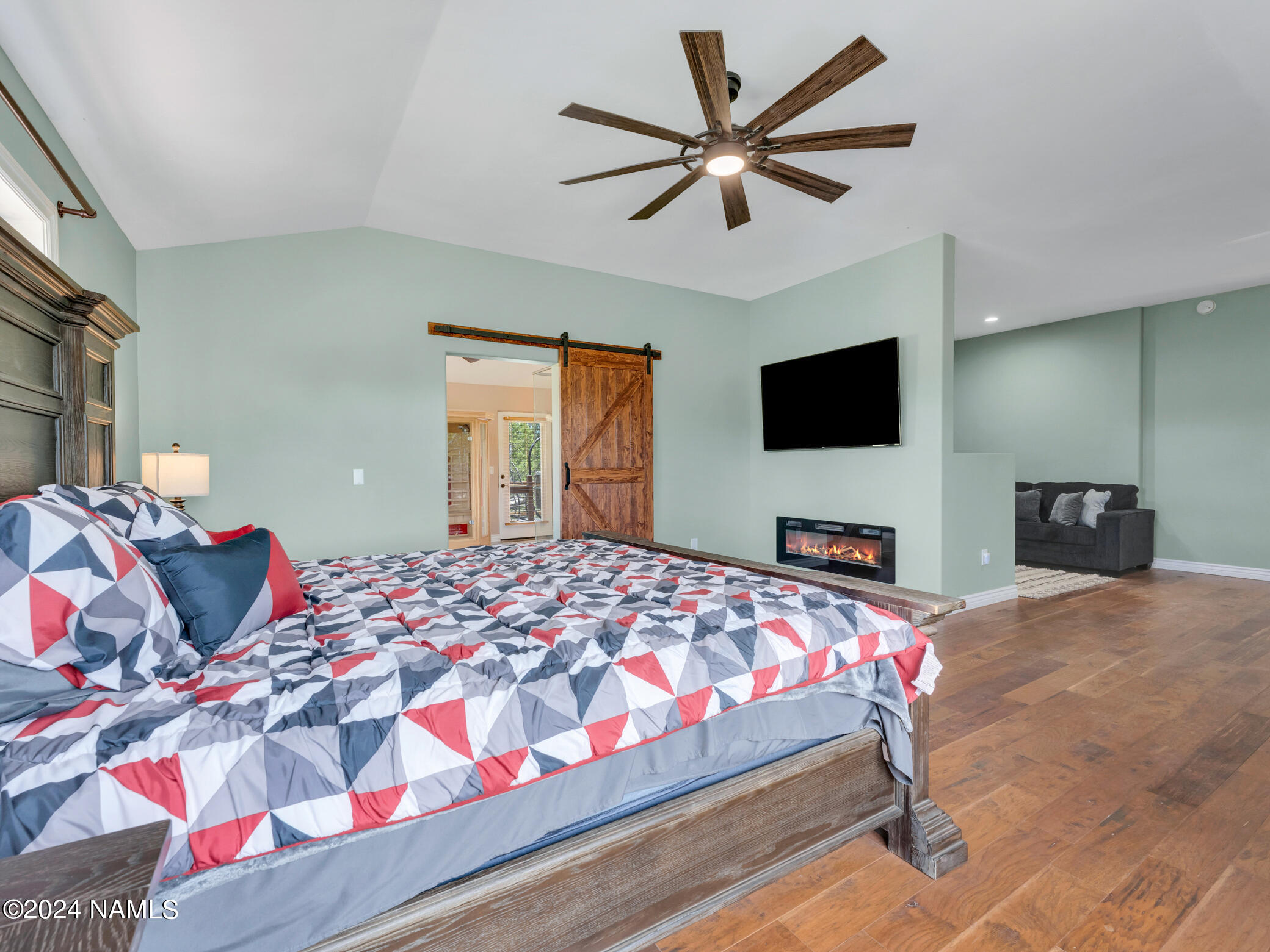 15312 Rabbit Brush Road Parks, AZ 86018 - Photo 39 of 59 a bedroom with a bed a chandelier and a flat screen tv