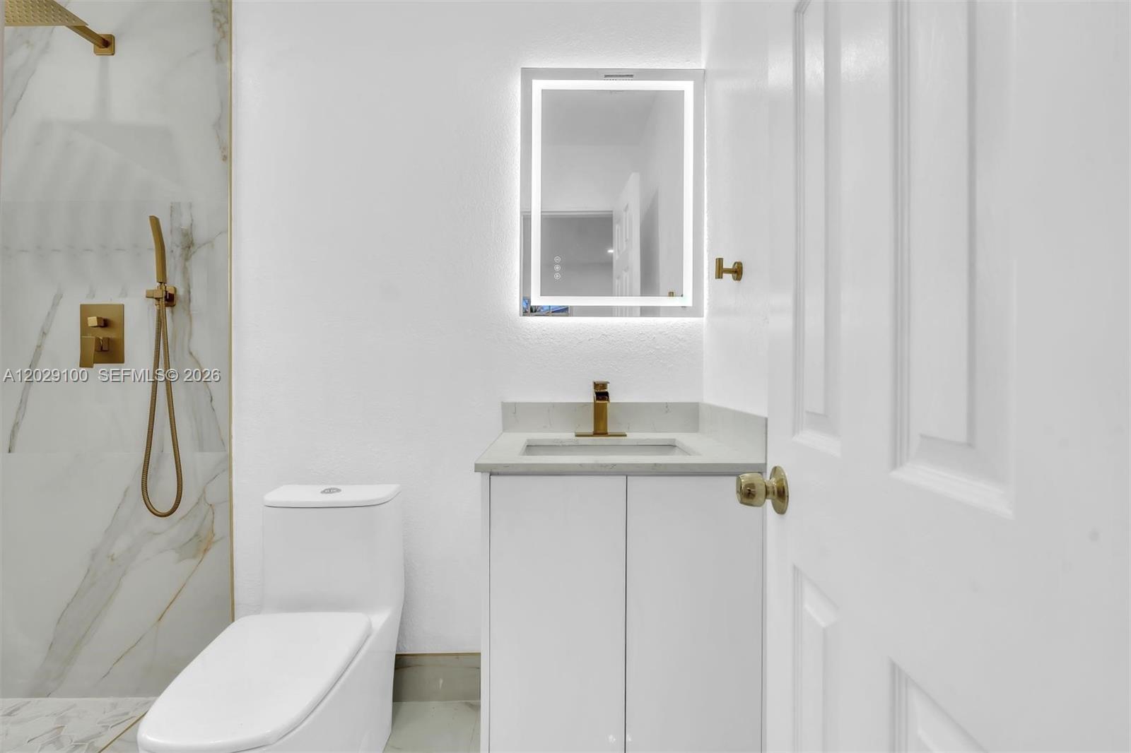 11790 Southwest 34th Street Miami, FL 33175 - Photo 38 of 56 a bathroom with a granite countertop toilet sink and mirror