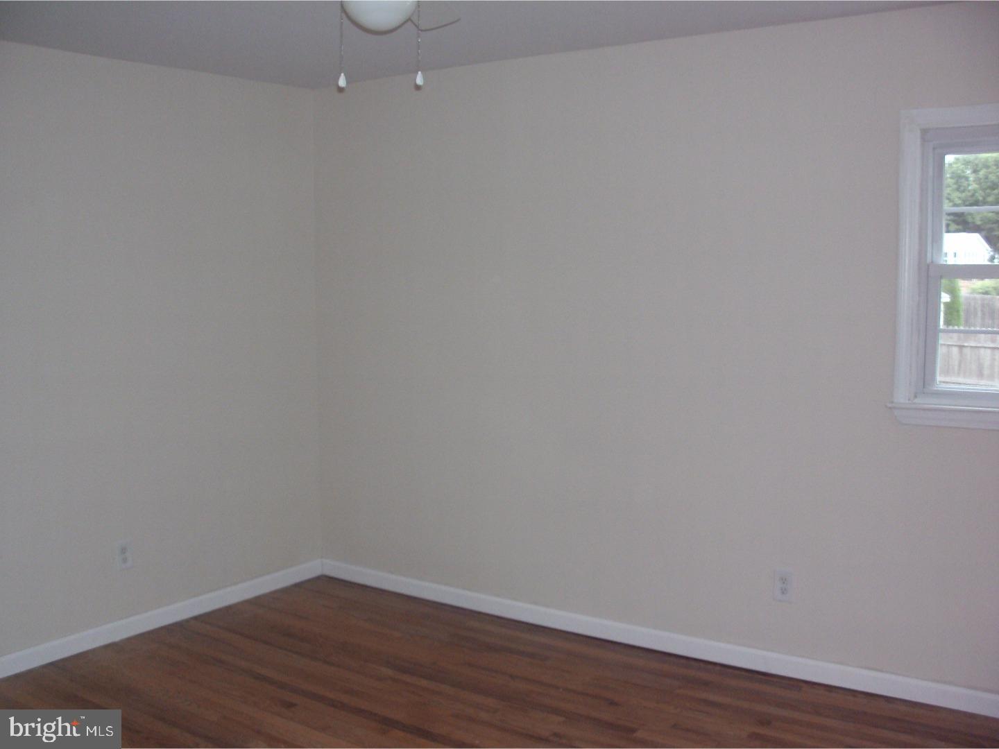 232 Oakfield Drive Newark, DE 19713 - Photo 8 of 14 a view of an empty room with wooden floor and a window