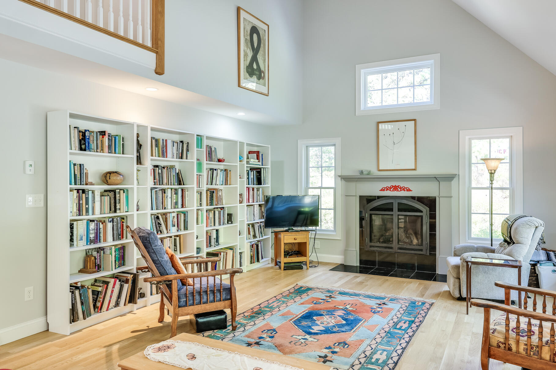 105 High Meadow Road Wellfleet, MA 02667 - Photo 22 of 52 a living room with furniture a fireplace and a book shelf
