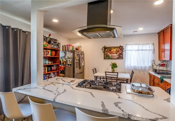 a kitchen with stainless steel appliances a table and chairs in it